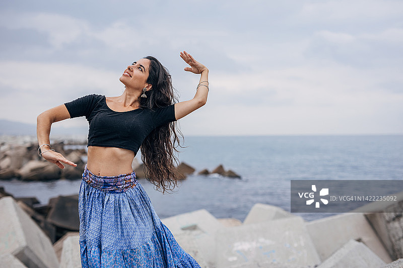 在海滩上跳传统舞蹈的印度女孩图片素材