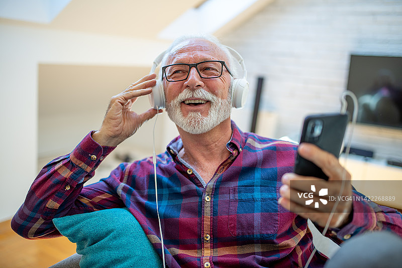 一名老年男子的肖像享受音乐股票的照片图片素材