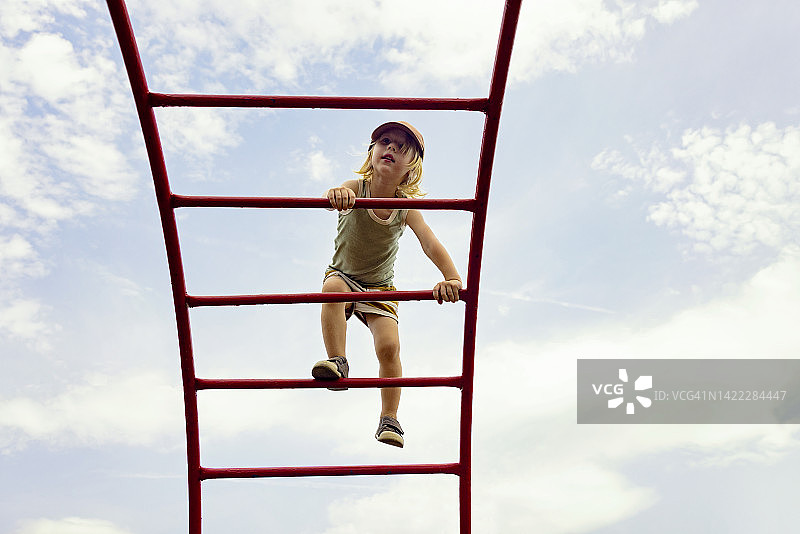 小男孩在操场攀爬图片素材