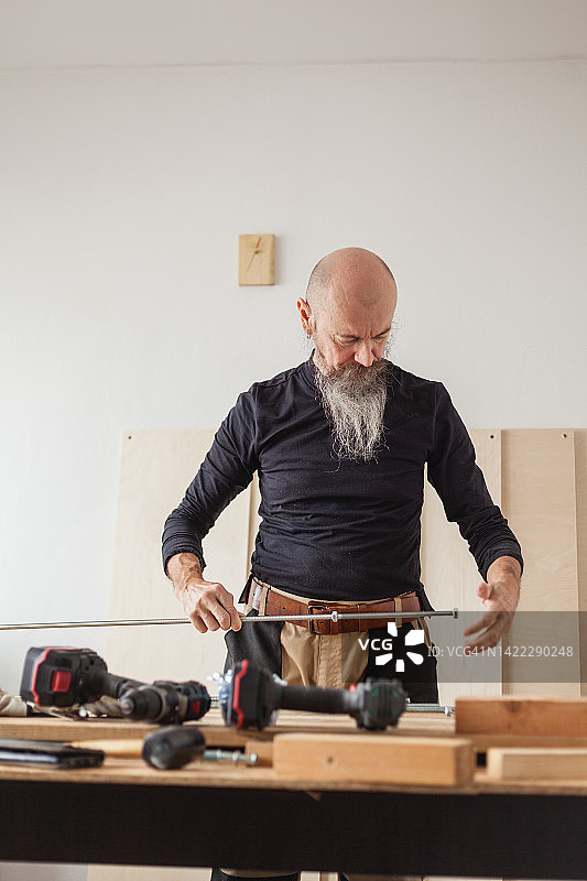 DIY家具制作：中年男子制作胶合板架子图片素材