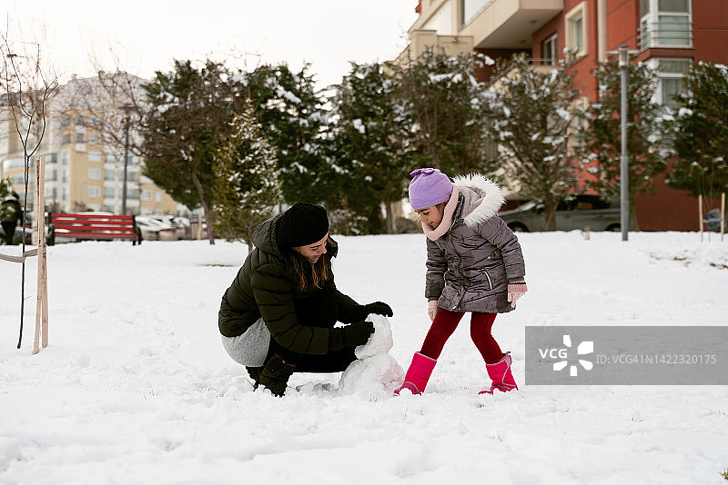 母亲和孩子在户外打雪仗图片素材