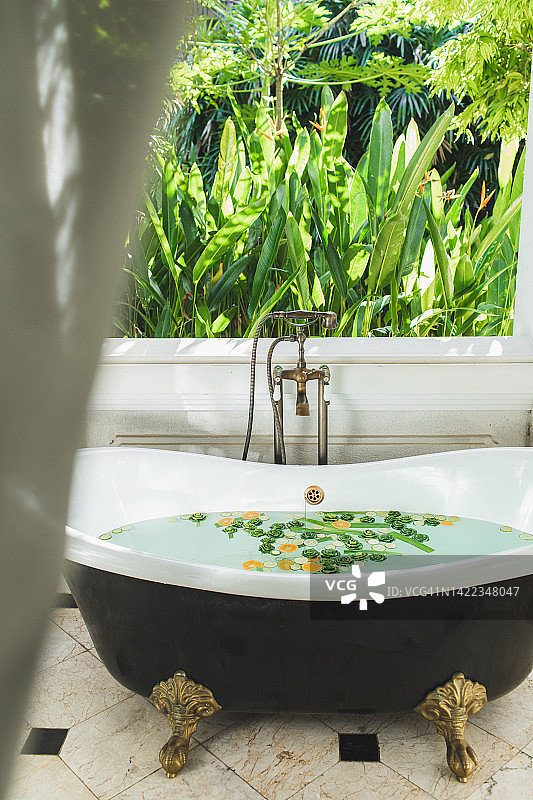 亚洲风格美容水疗护理：热带花园景观的室外浴缸图片素材