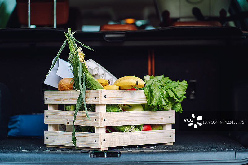 快速运送食物，汽车后备箱里装着新鲜有机蔬菜和水果的木箱图片素材