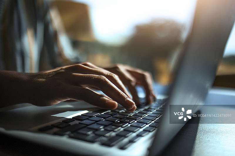 笔记本电脑键盘上的手部特写图片素材