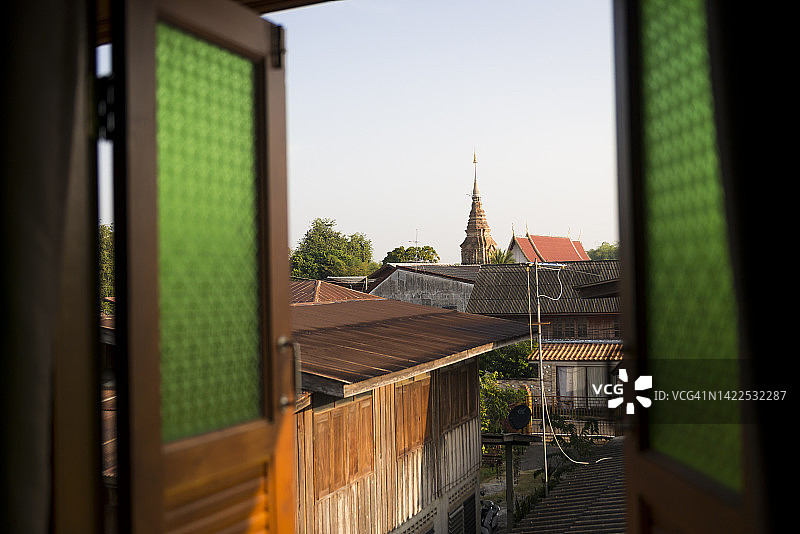 透过窗户看泰国帕府西ชุม寺的古老宝塔图片素材