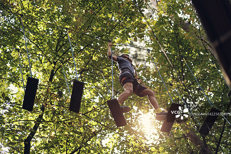 在高空绳索课程中行走的少年图片素材