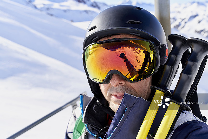 戴眼镜的成年人身穿滑雪服和运动装备，穿着暖和的外套看着镜头的微笑肖像图片素材