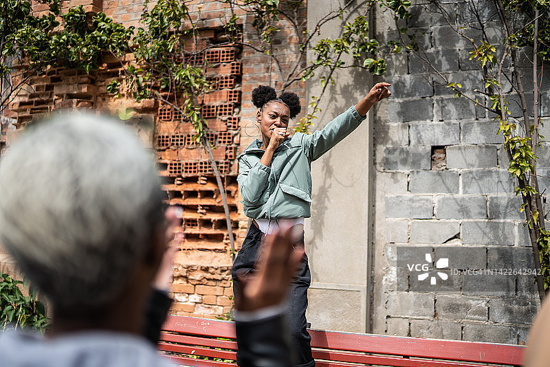 年轻女子在街头为朋友唱歌图片素材