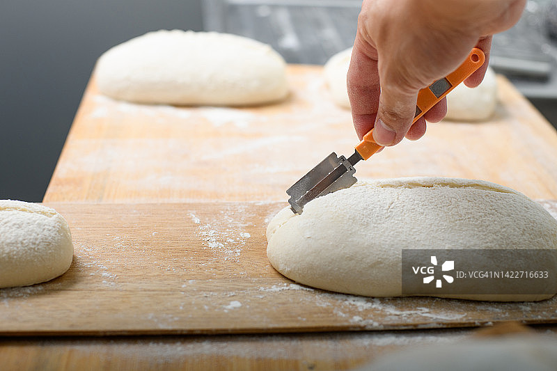 用剃须刀片给酸面包划痕图片素材