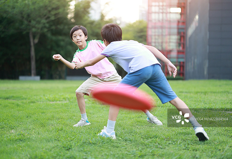 小男孩在公园里玩飞盘图片素材