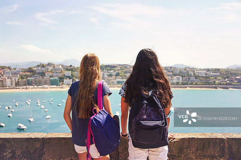 背着背包的少女眺望大海图片素材