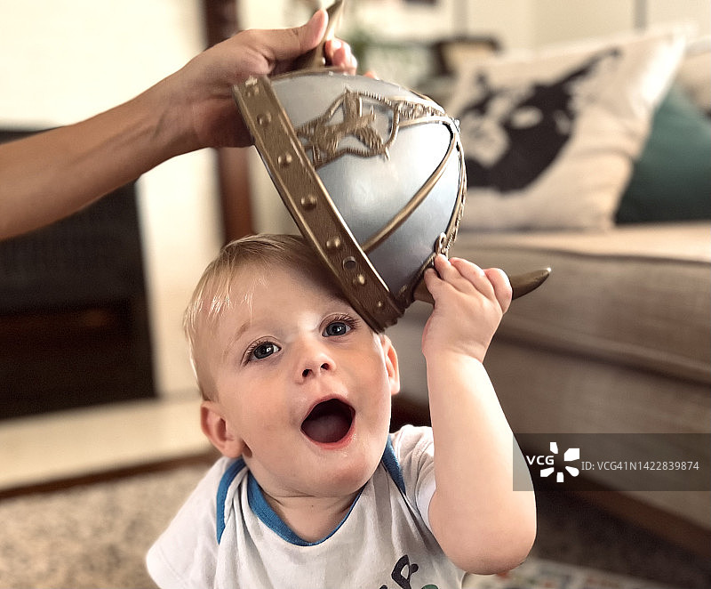 戴着维京头盔的男婴，妈妈拿着头盔图片素材
