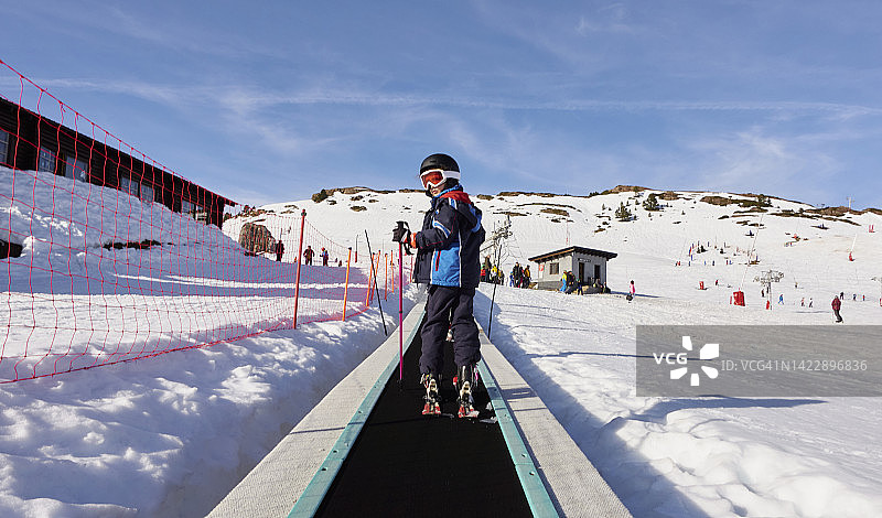 滑雪女孩站在滑雪场的传送带上图片素材