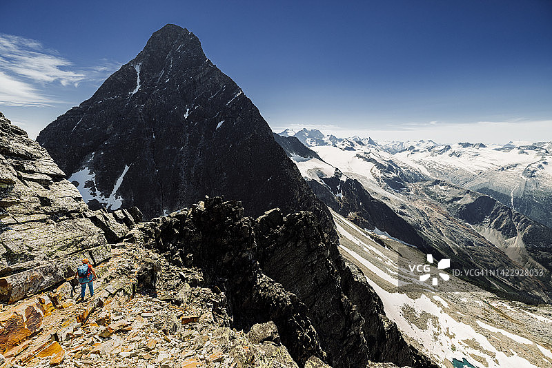 登山者在山坡的岩架上徒步图片素材