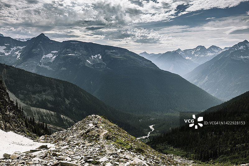一个人在山谷上方的高山小径上徒步图片素材