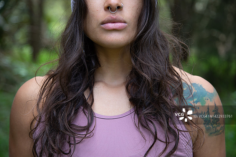佩戴纹身的运动装女子在自然环境中的肖像特写图片素材
