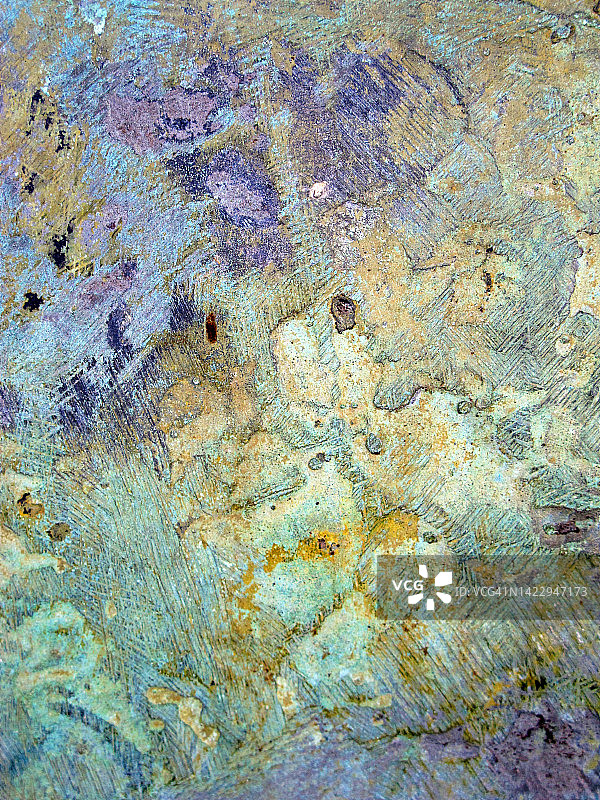 法国巴黎金属板上黄色、蓝色、绿色和紫色风化油漆层图片素材
