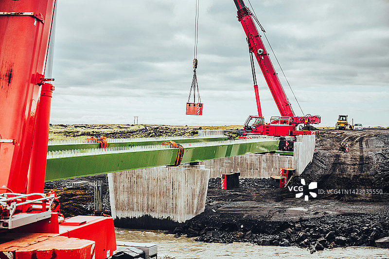 大型起重机在冰岛环路高速公路上建造新的桥梁连接。图片素材