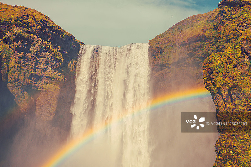阳光明媚的冰岛斯科加瀑布与彩虹图片素材