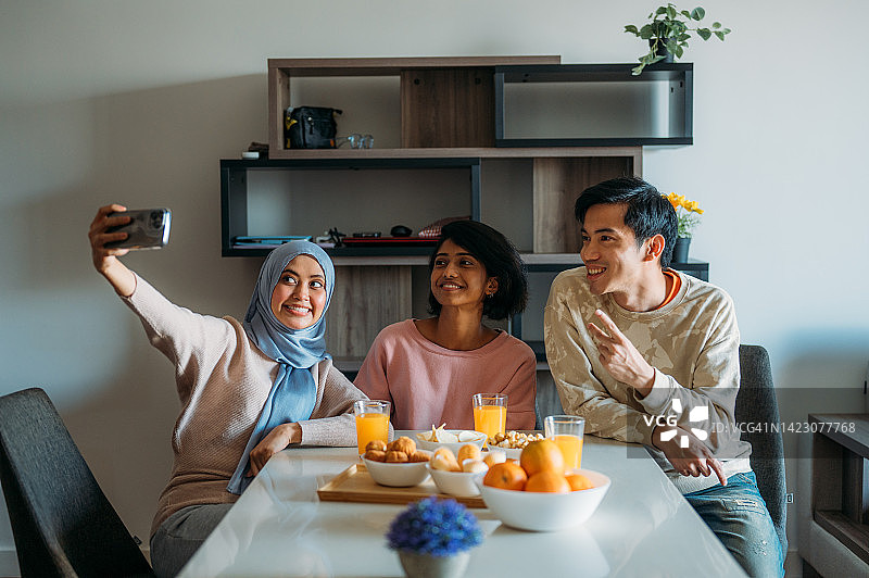 在家用智能手机自拍的微笑的多民族朋友图片素材