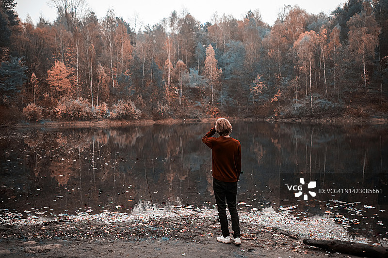 在湖边的长发毛衣男人图片素材
