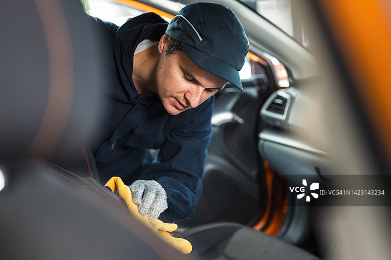 男人用超细纤维布清洁汽车内饰图片素材