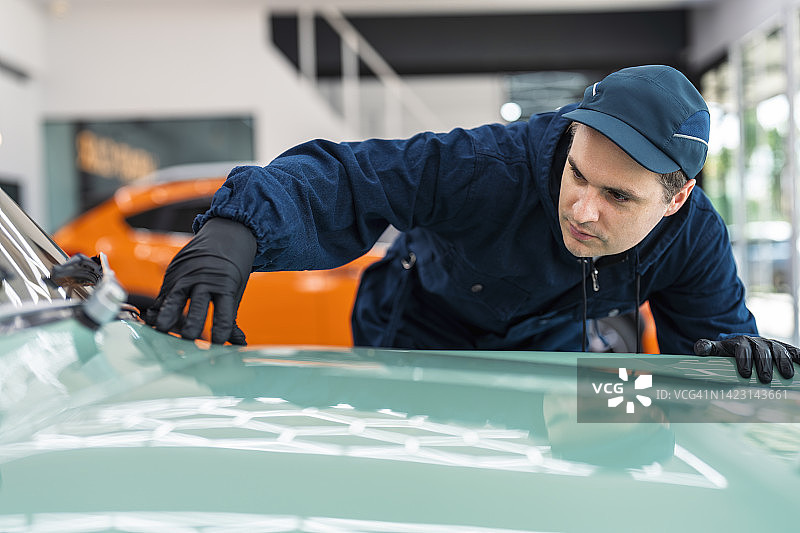 汽车美容服务中检查绘画和抛光工作的技师图片素材