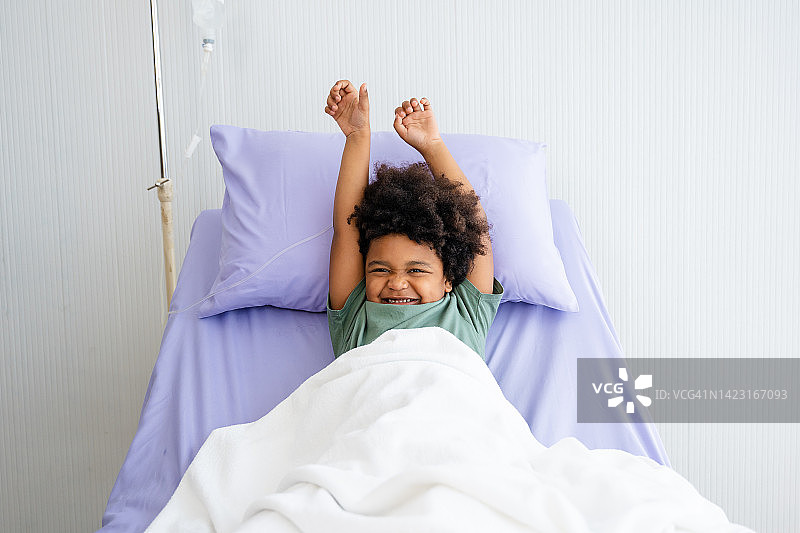 躺在医院病房里微笑的黑人小男孩图片素材
