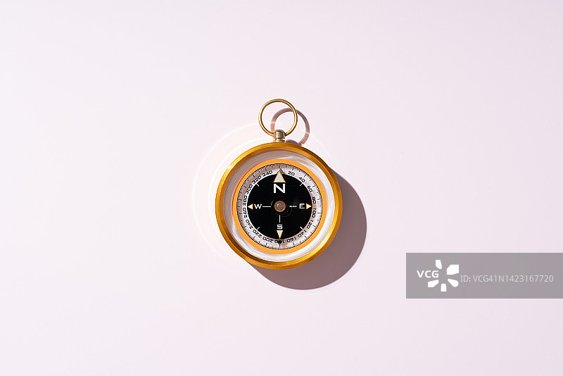 粉色背景上的金色导航罗盘图片素材