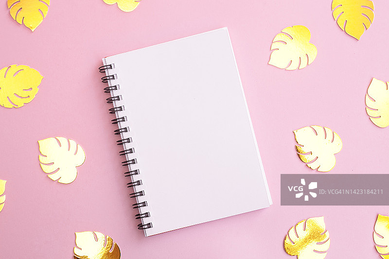 粉红色背景和金色树叶纸屑上的白色空白便签纸，带有文字复制空间图片素材