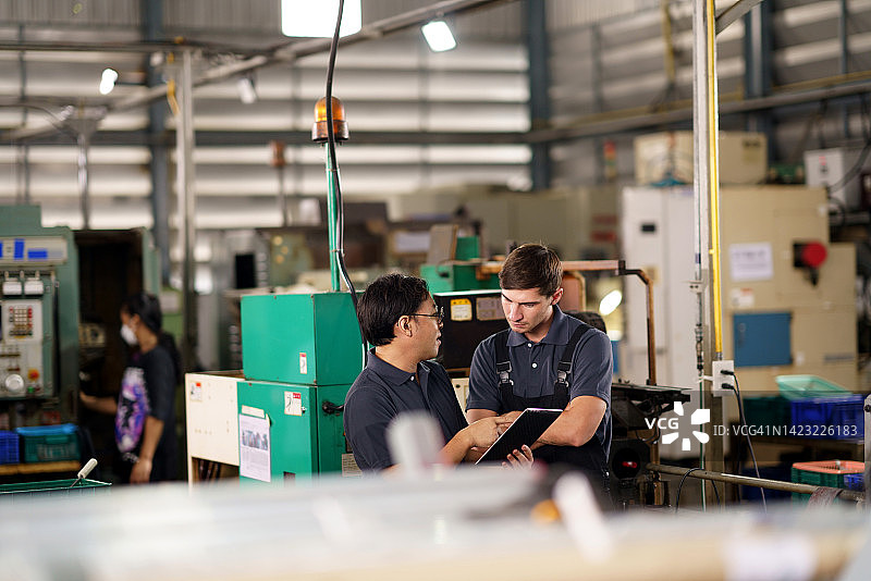 工业厂房工程师在控制室内合作图片素材