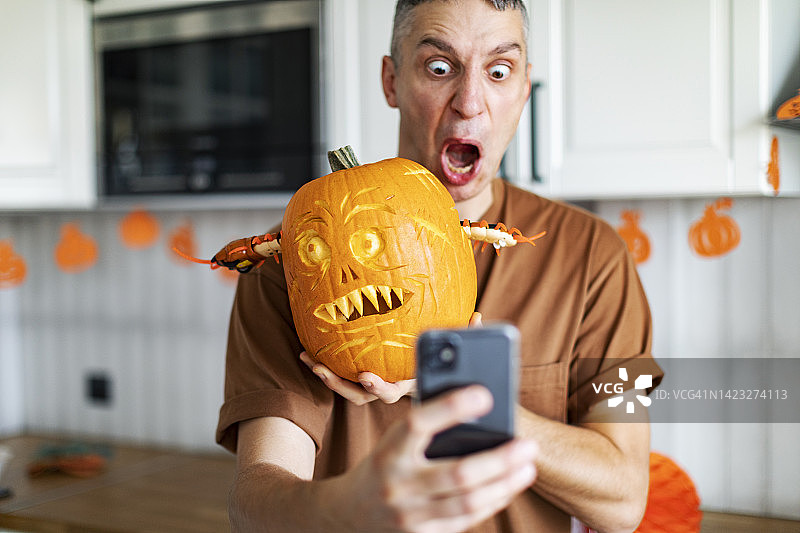年轻男人用万圣节南瓜自拍图片素材