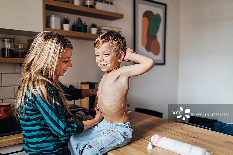 充满关爱的母亲给儿子喂水痘药图片素材