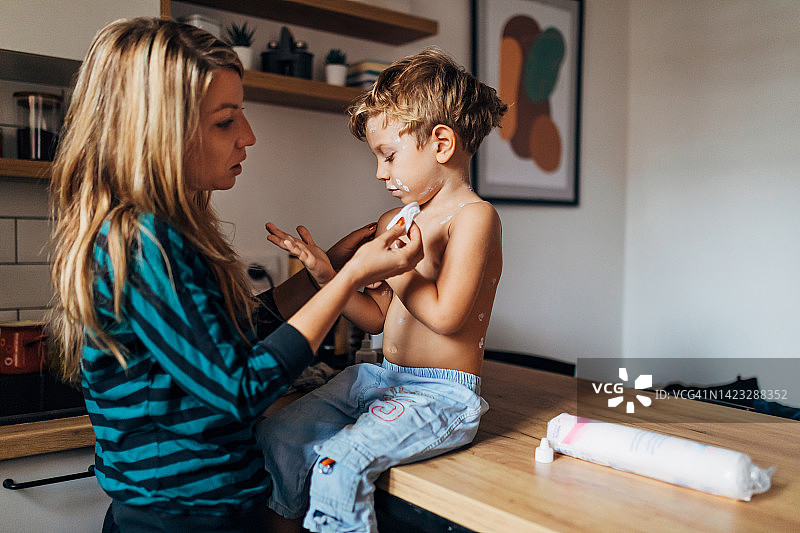 母亲给儿子喂药，呵护他的健康图片素材