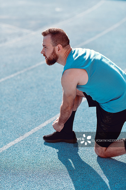 系鞋带准备跑步的男运动员图片素材