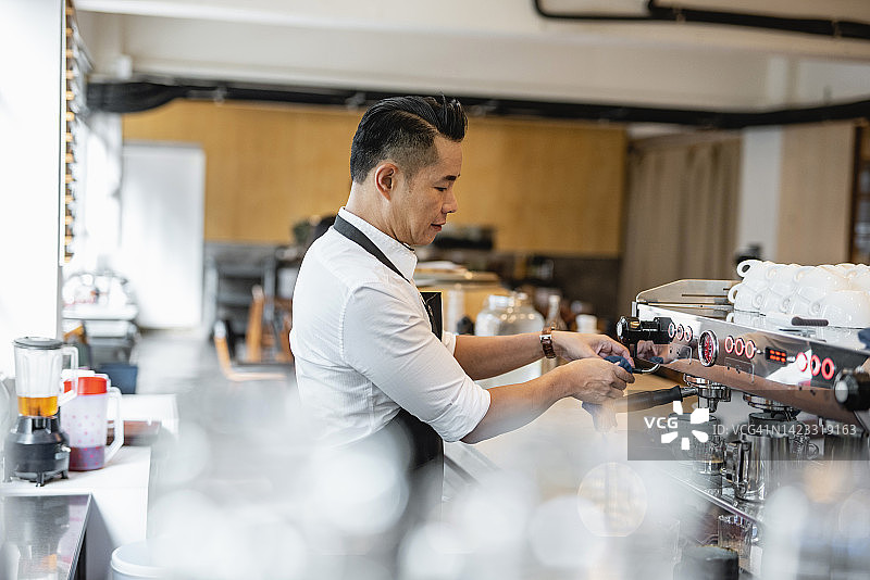 年长的男人在香港咖啡馆制作咖啡图片素材