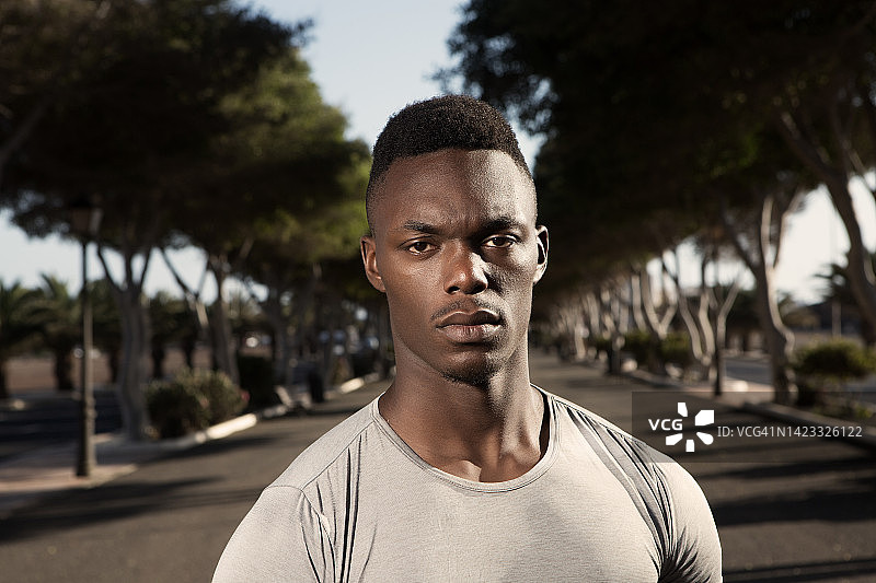 自信的黑人男跑步者站在路上看着镜头图片素材