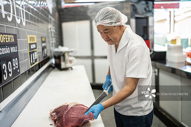 肉铺师傅在肉铺切肉图片素材