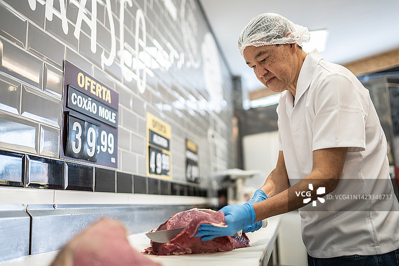 肉铺师傅在肉铺切肉图片素材