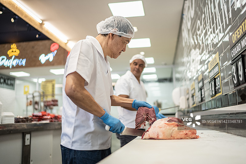 肉店里屠夫正在切肉图片素材