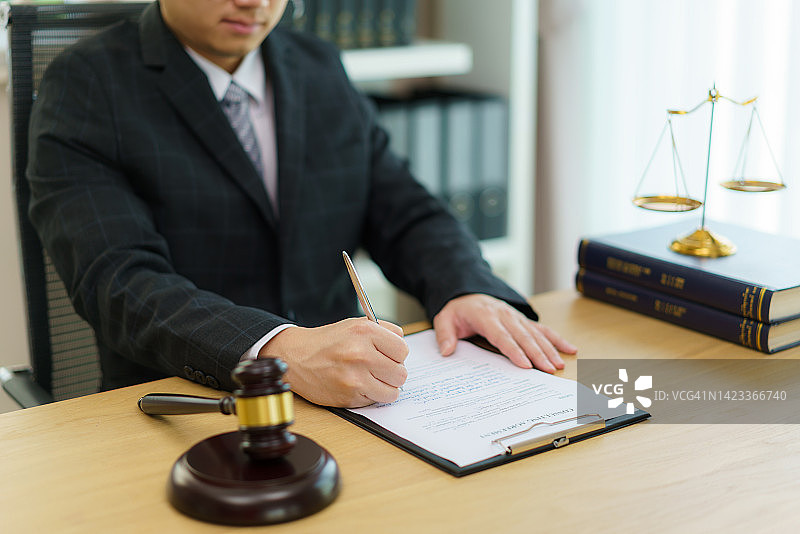 律师在办公室工作，公证员签署文件。顾问律师、司法和法律、律师、法院法官概念图片素材