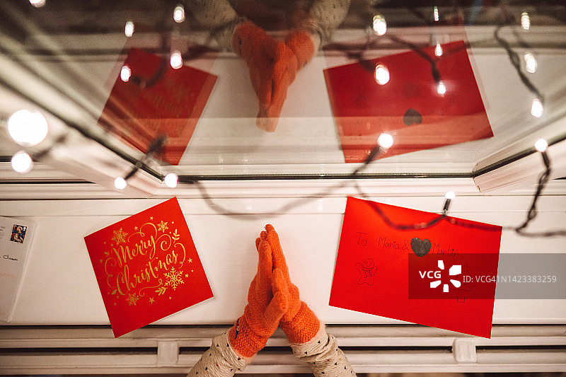 俯视：圣诞节装饰窗台上戴红色手套的儿童双手图片素材