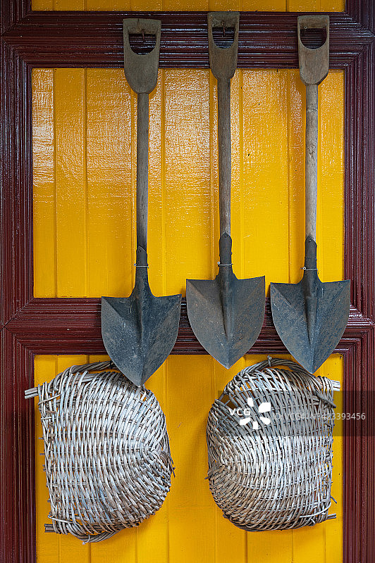 挂在墙上的柳条筐和铲子特写图片素材
