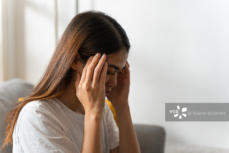 独自在家头痛的年轻亚洲女性图片素材
