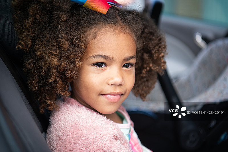 坐在汽车后座向外看的可爱女孩图片素材