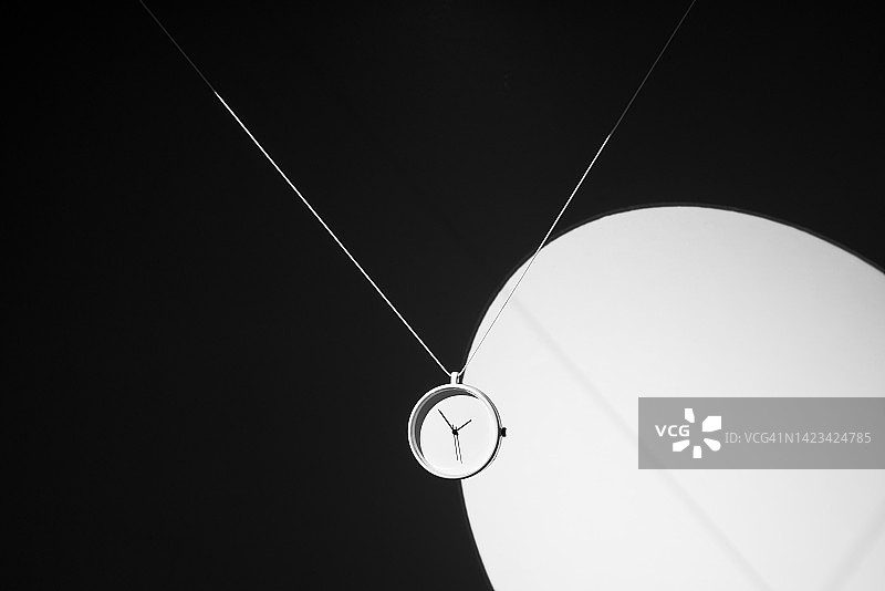 黑暗中照亮时钟的聚光灯，单色图片素材