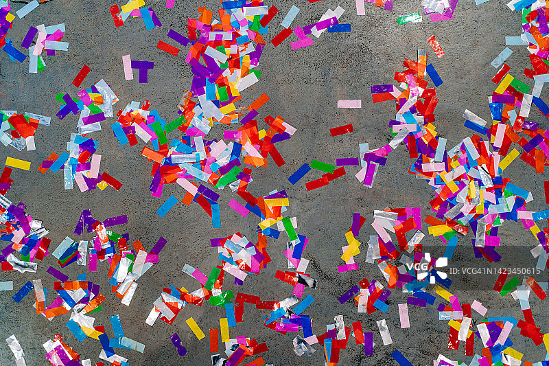 派对后水泥地上散落的彩色纸屑，扁平风格图片素材