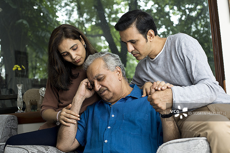 情侣在家安慰沮丧的老父亲图片素材