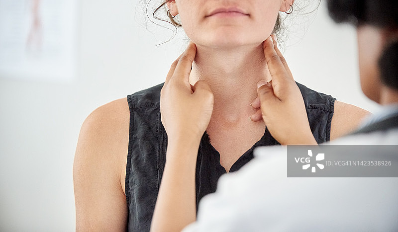 医生在诊所检查年轻患者的甲状腺图片素材