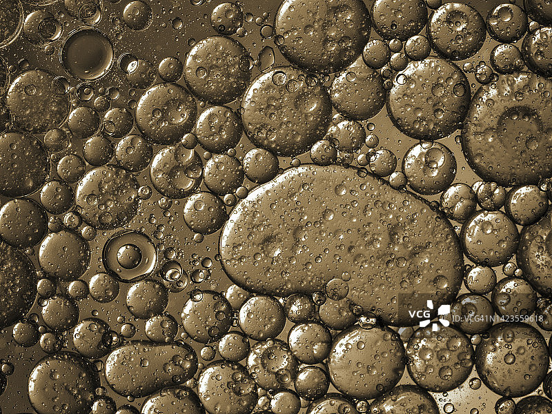 金色液体背景上的气泡和水滴纹理抽象形状图片素材